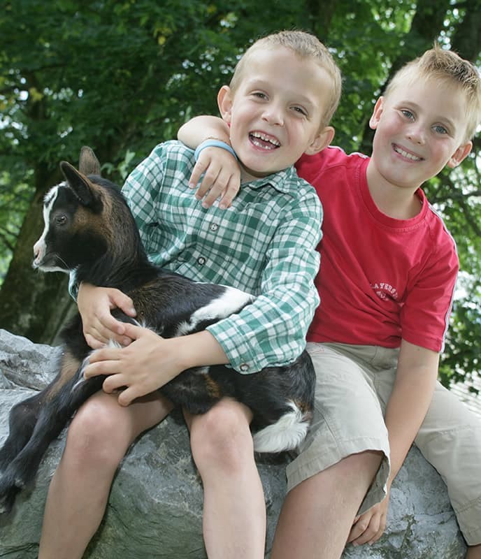 Zwei Jungen mit einem kleinen Zicklein