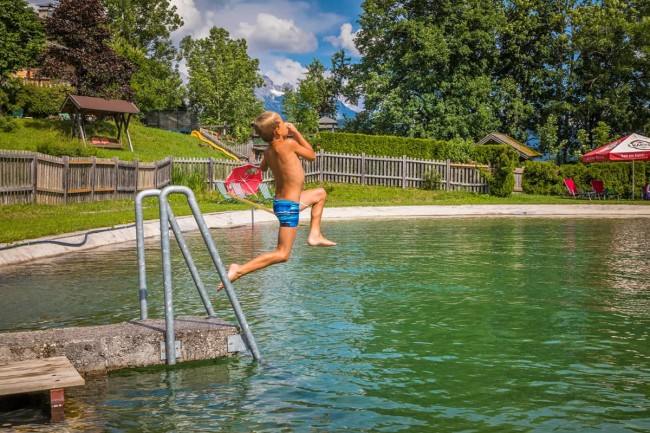 Abkühlung im Badeteich beim Sprung ins Wasser